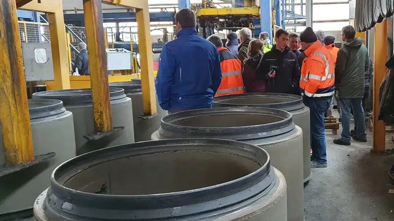 Teilnehmer einer Werksführung in der Produktionshalle eines Betonwerks