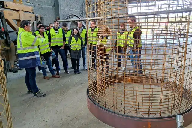 Teilnehmer einer Werksführung in der Produktionshalle eines Betonwerks