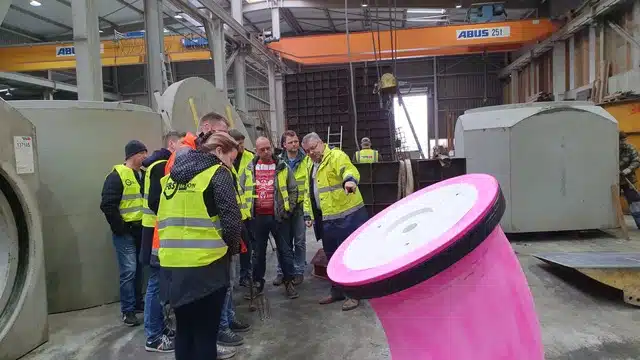 Teilnehmer einer Werksführung in der Produktionshalle eines Betonwerks