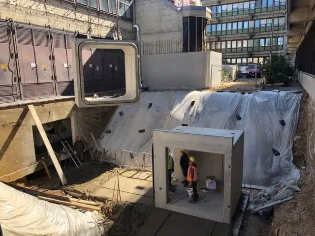 Bauarbeiter beim Einbau eines Betonfertigteils auf einer Baustelle